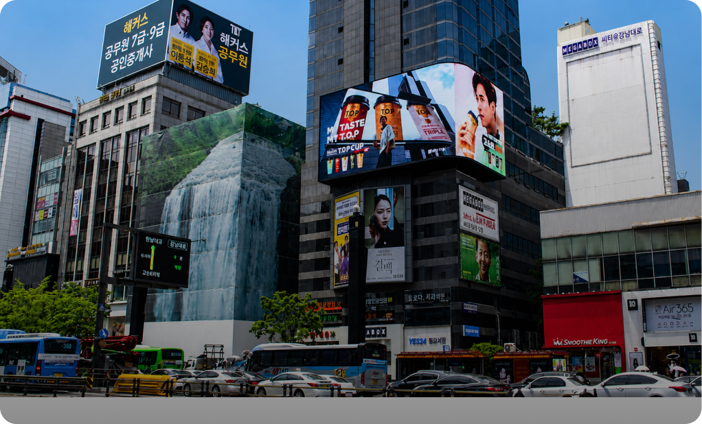 Digital billboards on building façades at a busy street intersection in Seoul, South Korea