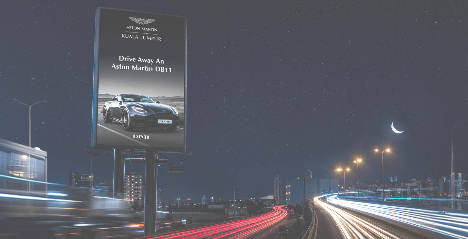 Aston Martin DB11 billboard beside a highway at night in Kuala Lumpur, Malaysia