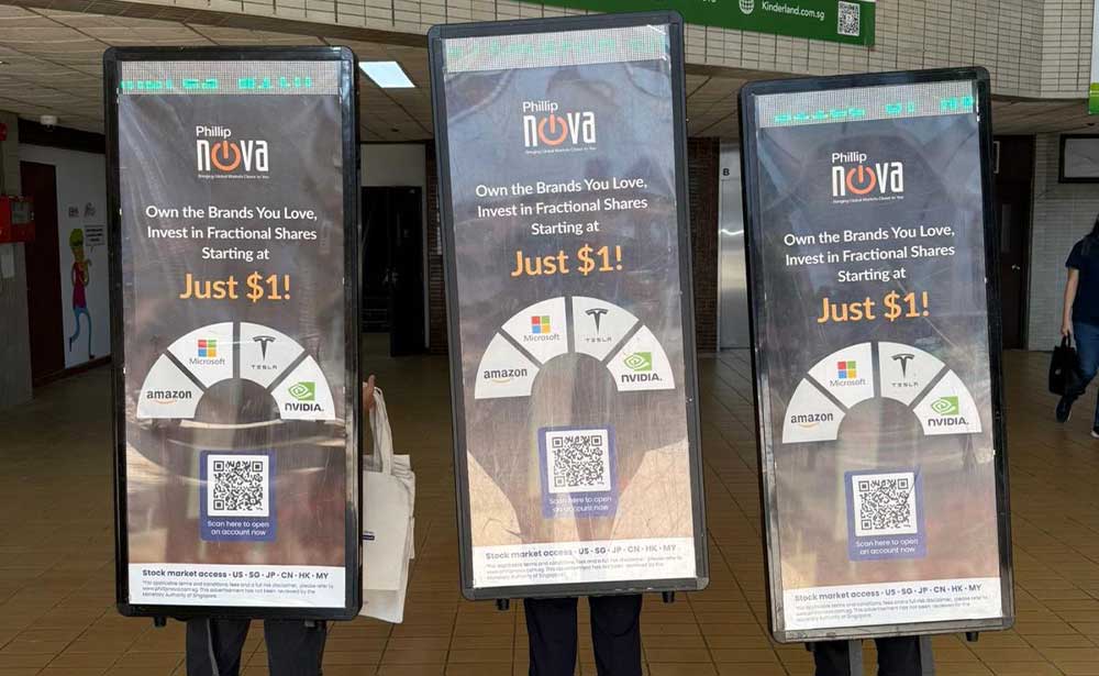 Three PosterWalker™ talents carrying Phillip Nova displays promoting fractional shares from $1