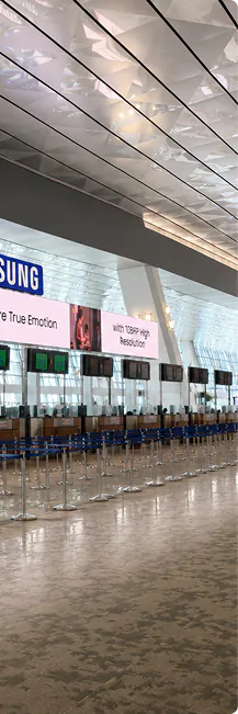 Samsung advertising on overhead screens in an airport check-in hall