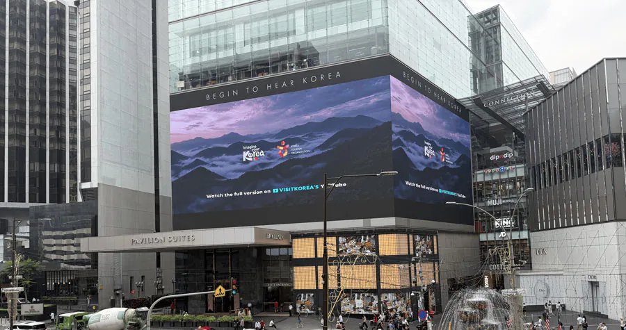 Begin to Hear Korea campaign on a wraparound building screen in Malaysia