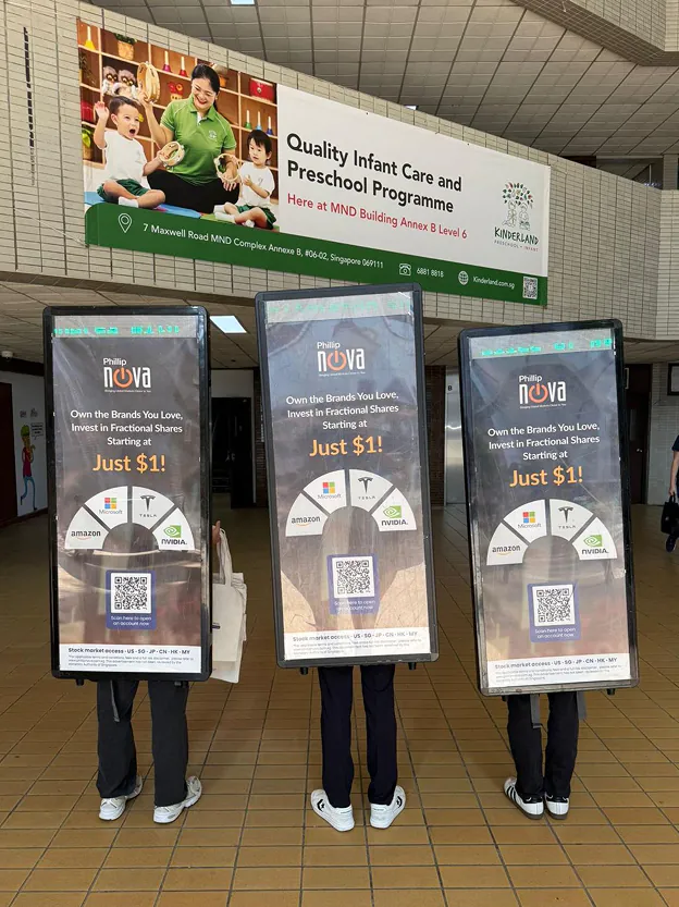 Phillip Nova PosterWalker™ team with digital backpack screens in a Singapore station concourse
